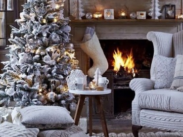 Kominek znacząco ociepla wnętrze i dodaje uroku świątecznej aranżacji. Główną rolę odgrywa w niej biała choinka...