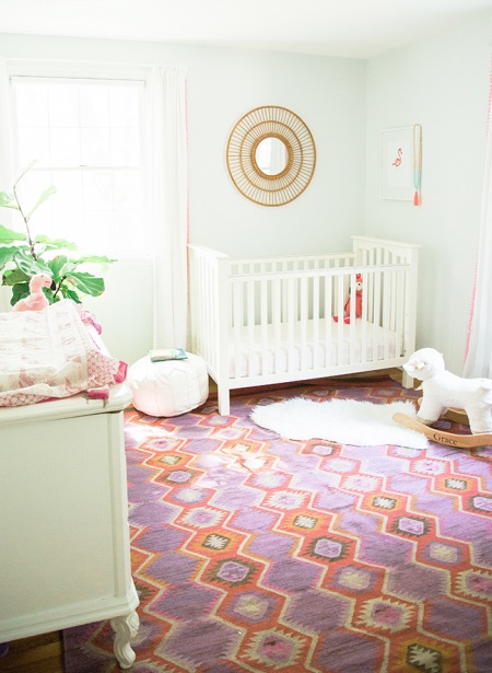 Wzorzysty kolorowy dywan w białym pokoiku dziecięcym