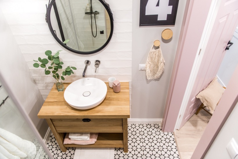 Skandynawski wystrój łazienki z drewnianą szafką i pastelowymi drzwiami