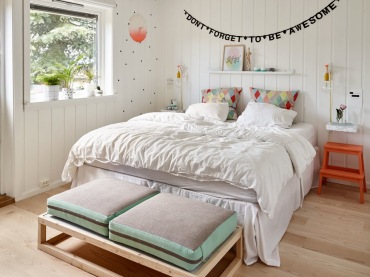 Przytulną sypialnię wzbogaca kilka dekoracji, jak np. wisząca nad łóżkiem typografia. Białe deski z drewna, jakie...