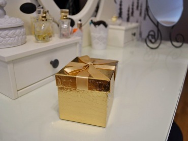 Flakoniki perfum i rozmaite dodatki pełnią dekoracyjną funkcję na białej toaletce. Złote pudełeczko wnosi do aranżacji...