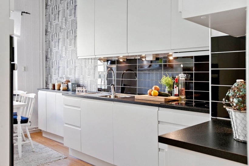 Graficzna tapeta ścienna, czarne płytki cegiełki w kuchni skandynawskiej z białymi szafkami i czarnymi blatami