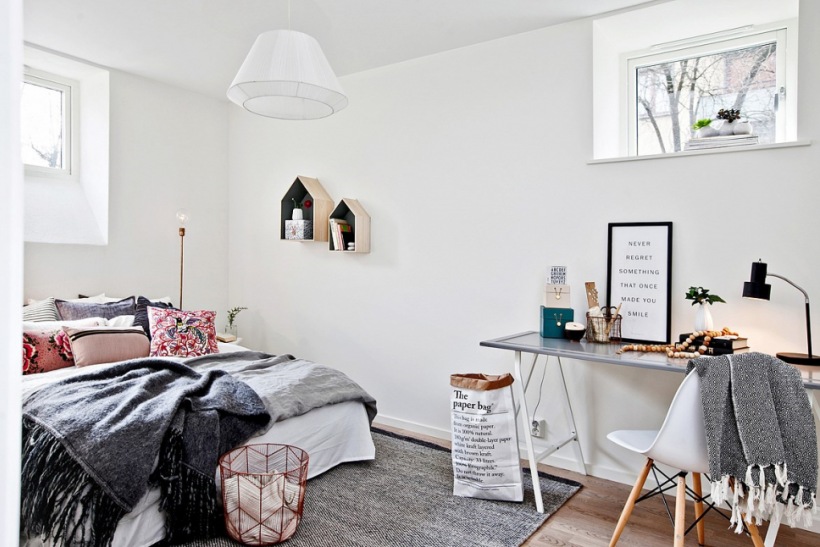 Skandynawska sypialnia w biało-szarej aranżacji z różowymi detalami