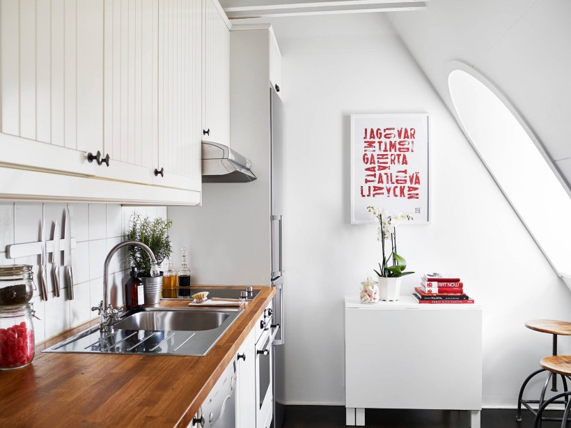 Biała kuchnia skandynawska w małym mieszkaniu na poddaszu