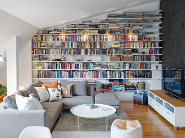 białe, ładne wnętrze na poddaszu - ciekawie rozwiązana biblioteczka na całej ścianie,dobrze zagospodarowana przestrzeń...