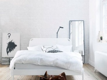 biała sypialnia z podłogą z drewnianych...