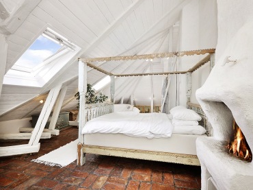 Czerwona terakota,bielone belki i łóżko w drewnianej ramie w białej sypialni na poddaszu (21516)