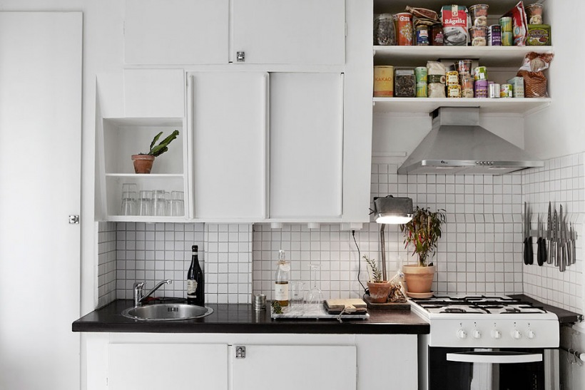Białe kwadratowe płytki na ścianie w białej kuchni skandynawskiej w nowoczesnym stylu