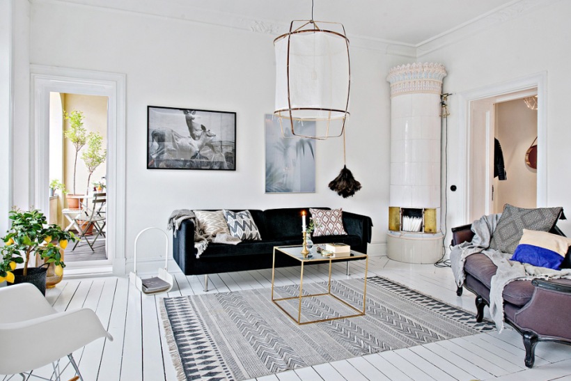 Czarna sofa nowoczesna,skandynawski dywan etno,kwadratowy stolik metalowy,lampa kokon na metalowym stelażu i stylowy wrzosowy szezlong w salonie