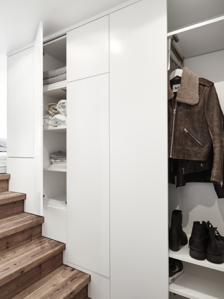 Zabudowa szaf garderobianych przy schodach z drewna w mieszkaniu