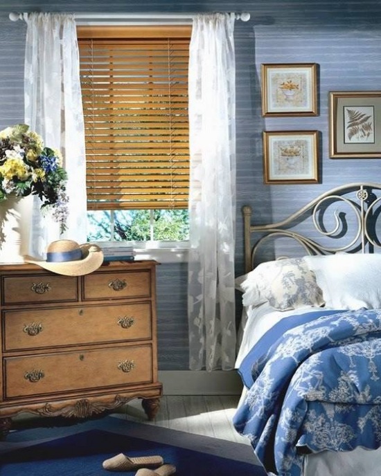 Błękitna sypialnia z drewnianymi żaluzjami i drewnianą stylową komodą