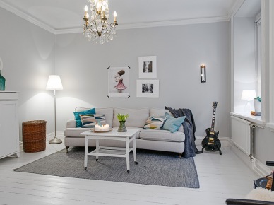 Aranżacja skandynawskiego salonu z białą podłogą,turkusowymi dekoracjami i szarym dywanem (21616)