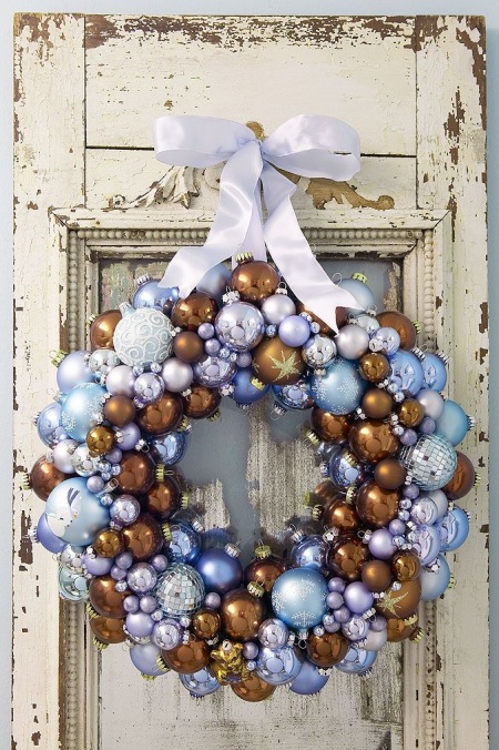Niebiesko-brązowe bombki w świątecznym wianku na drzwiach