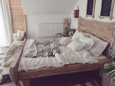 W sypialni znajduje się bardzo oryginalne łóżko. Jego ramę wykonano z naturalnych desek o nieregularnym kształcie....