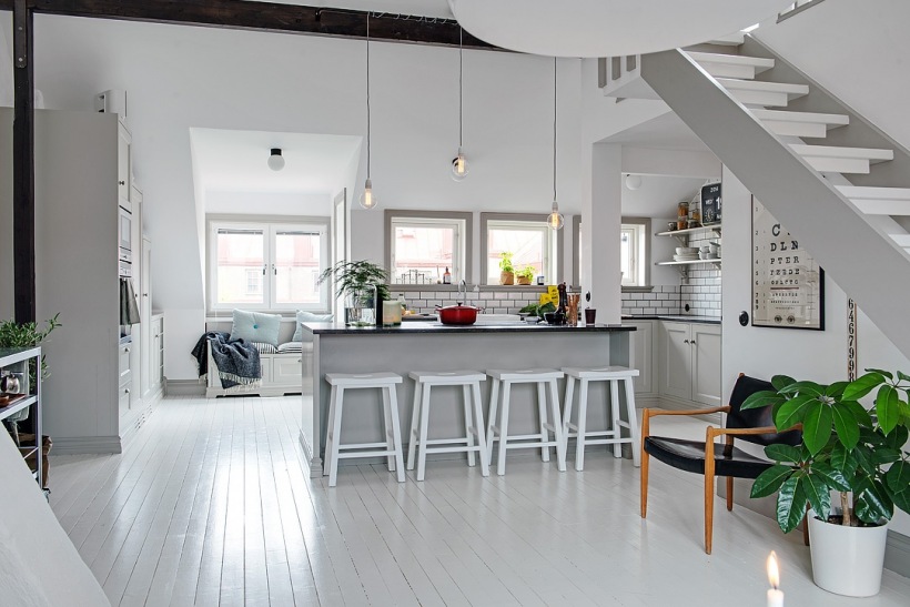 Otwarta przestrzeń mieszkania z ażurowymi białymi schodami