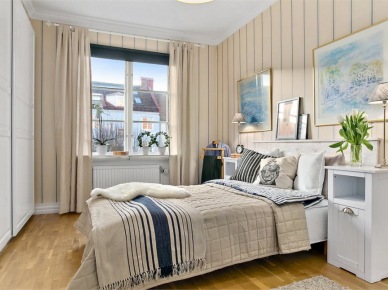 Biało-beżowa sypialnia skandynawska z granatowymi dodatkami na łóżku (27688)