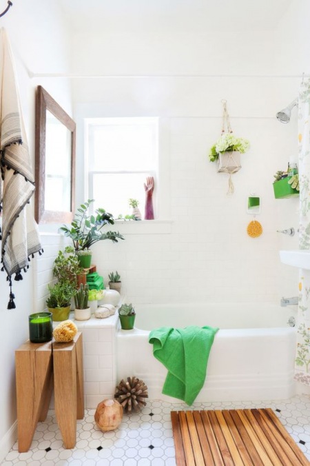 Biała łazienka z zielonymi i drewnianymi dodatkami