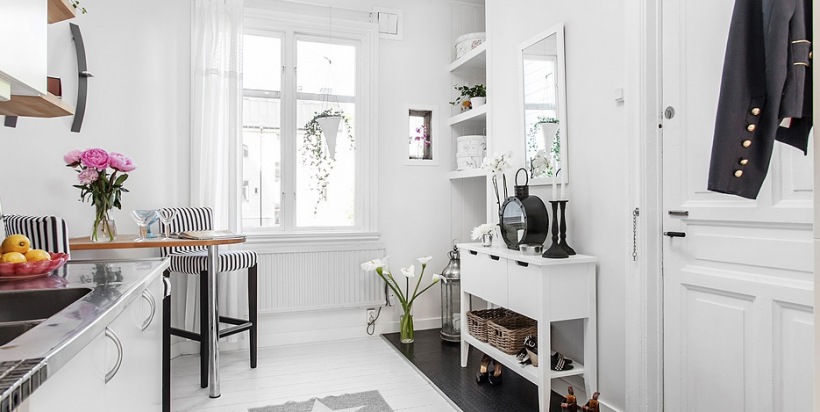 Aranżacja biało-czarnej kuchni razem z przedpokojem w malym mieszkaniu