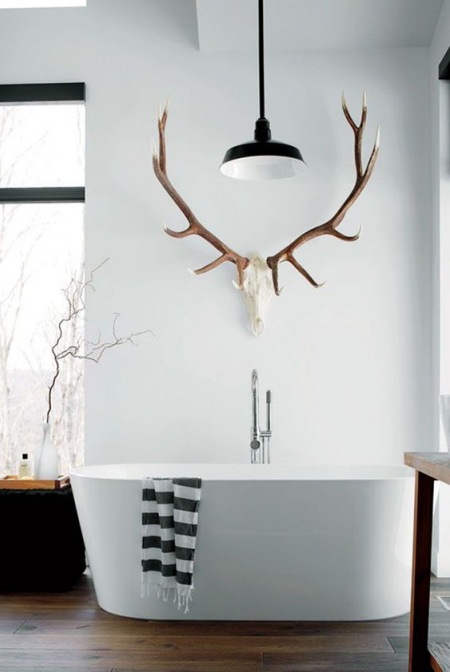 Biała łazienka z porożem i czarnymi dodatkami w skandynawskim stylu
