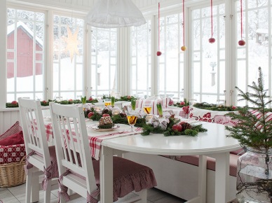 Biały drewniany stół z krzesłami w stylu skandynawskim,ławki białe ze świątecznymi poduszkami,biało-czerwone dekoracje świąteczne na wstążkach (47944)