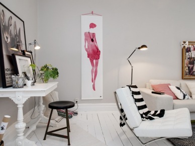 Biało-różowy plakat i złocone ramy na ścianie w białym salonie z drewniana konsolką i czarnymi dodatkami (24450)