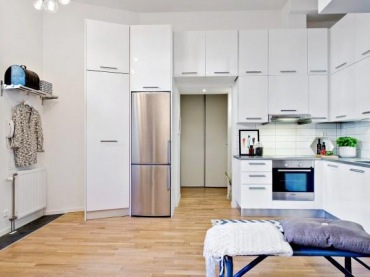 Wysokość mieszkania pozwoliła na zabudowanie kuchni pojemnymi szafkami niemal pod sam sufit. Pomagają zorganizować przestrzeń i ułatwiają przechowywanie kuchennych...