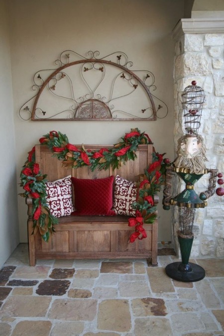 Czerwone dekoracje świąteczne z gwiazdy betlejemskiej i poduszek na ławce