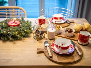 Zastawa oraz dekoracje na stole w jadalni mają świąteczny charakter. Dzięki temu całe wnętrze wypełnia ciepło i...