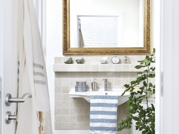 Biała łazienka z szarymi płytkami i ze stylowym rzeźbionym lustrem w złotych ramach (24839)