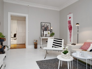 Biała konsolka i białe fotele z sofą w skandynawskim salonie z różowym plakatem i różowymi poduszkami (24451)