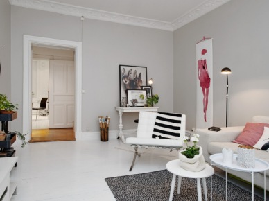 Biała konsolka i białe fotele z sofą w skandynawskim salonie z różowym plakatem i różowymi poduszkami (24451)