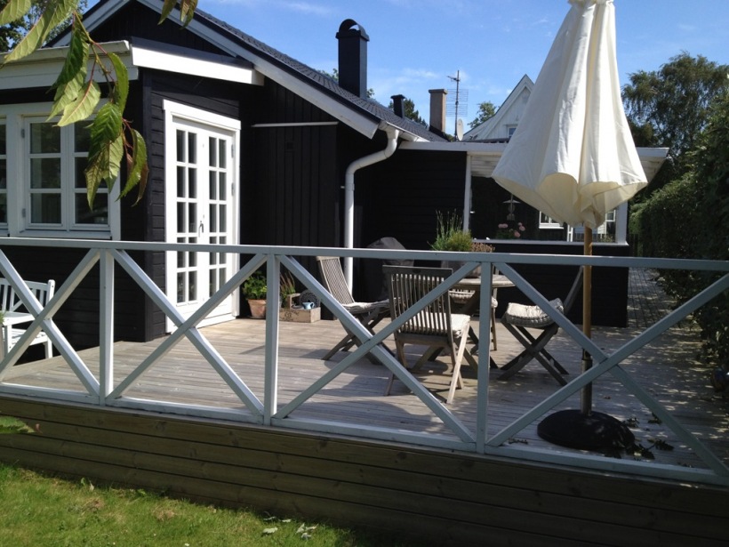 Skandynawski  dom z czarnych desek i z białymi oknami