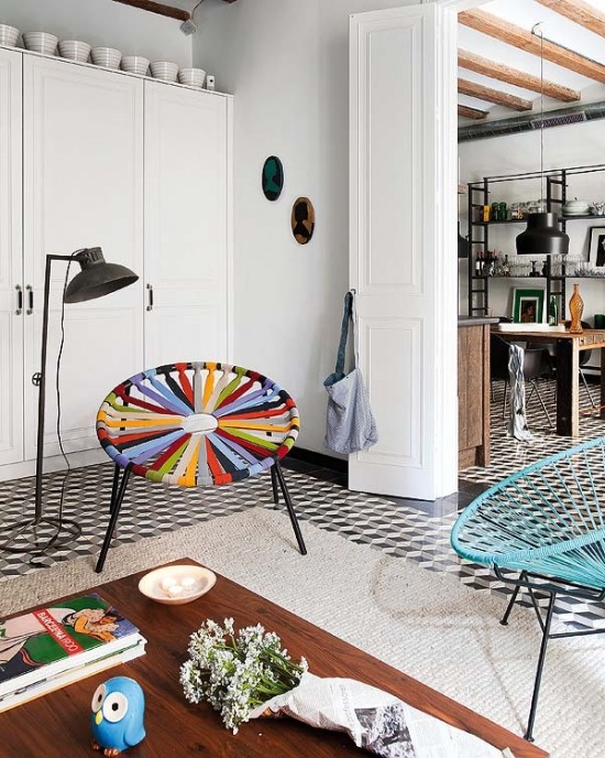 Czarno-biala mozaika , kolorowe fotele i białe szafy w salonie