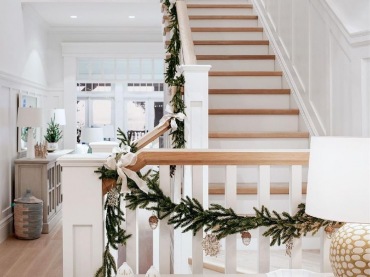 W przedpokoju postawiono na bardzo prostą, świąteczną ozdobę na poręczy schodów. Naturalne gałązki świerku zawieszono w...