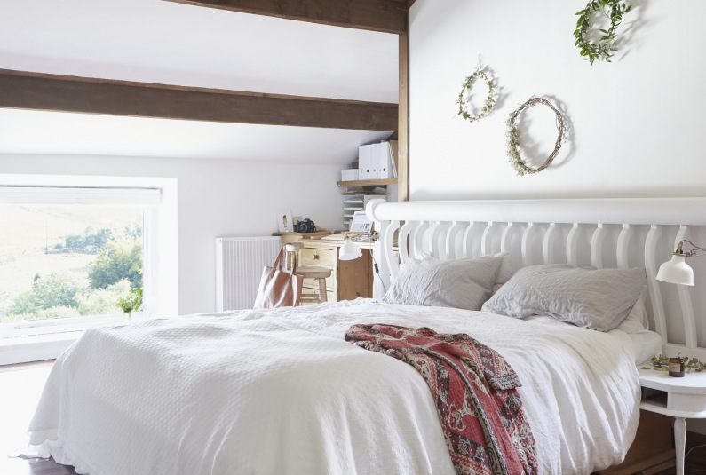 Sypialnię na poddaszu urządzono w białym kolorze. Uzupełniające aranżację drewniane akcenty wprowadzają przyjemną...