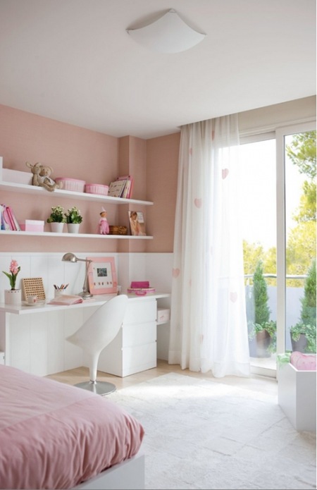 Białe biurko przy różowej ścianie z półkami