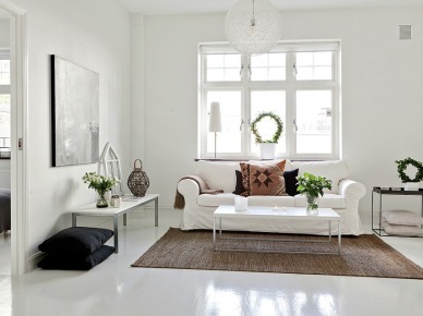 Biała sofa,jutowy dywan i czarne poduszki w salonie (18390)