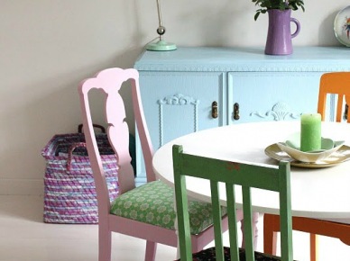 Okrągły bały stół z pomarańczowym, zielonym i różowym krzesłem (21994)