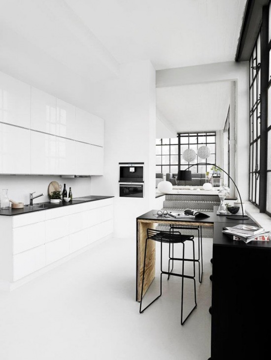 Nowocześnie i minimalistycznie w białej kuchni z czarnym stołem i metalowymi krzesłami