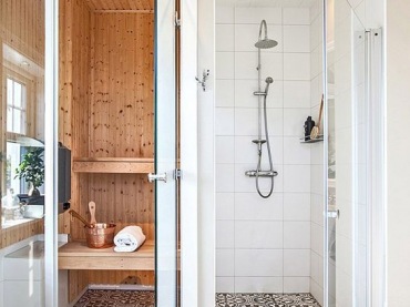 Zachwycająca aranżacja sauny i łazienki, które łączy podłoga z płytek azulejos. Zarówno prysznic w śnieżnobiałych...