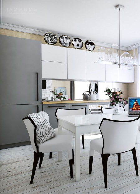 Biało-szara nowoczesna kuchnia z lustrzaną ścianą między szafkami,patynowana biała podłoga z desek,biały prostokątny stół i białe foteliki z czarnymi nóżkami i lamówkami