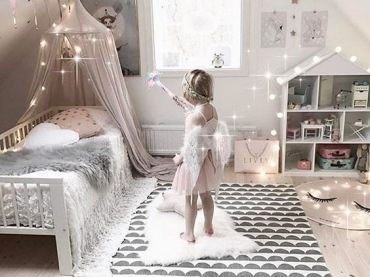 Wzorzysty dywan w pokoju dziecięcym na poddaszu urozmaica pastelową całość. Baldachim nad łóżeczkiem oraz skośne sufity...