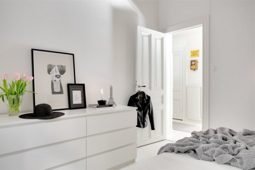 Minimalistyczna aranżacja białej sypialni z czarnymi detalami