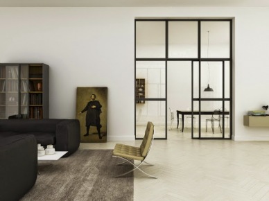 Metalowa i przeszklona ściana z drzwiami w aranzacji salonu z czarnymi sofami,szarym dywanem i miodowo-złotym nowoczesnym fotelem na metalowych nogach płozach (25722)