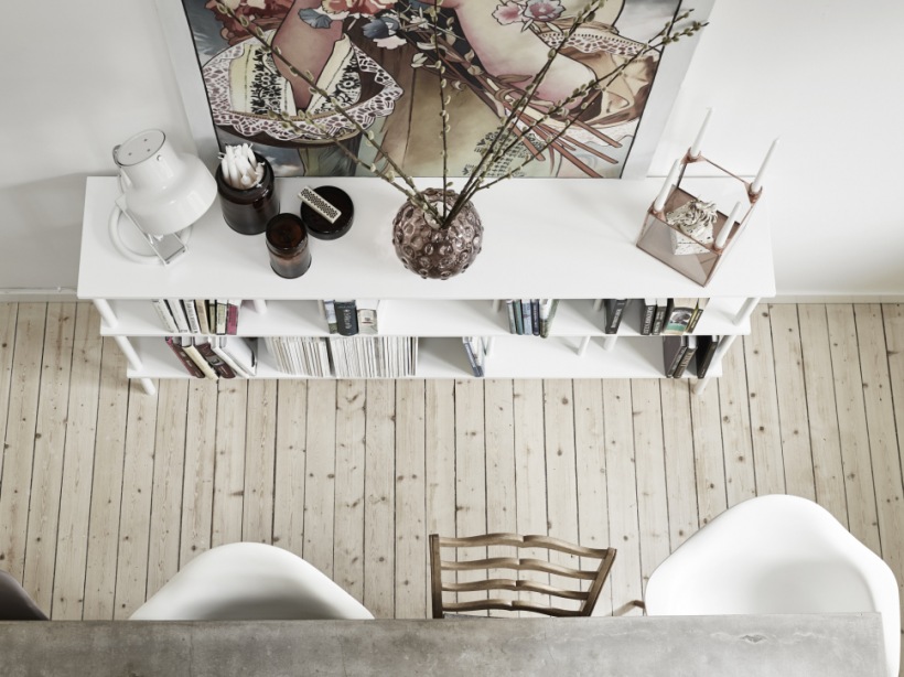 Wąskie deski z naturalnego drewna biała komoda i duży plakat w salonie