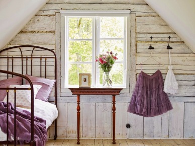 Drewniane przecierane deski na ścianie w sypiani na poddaszu,kute łóżko i stylowa konsolka z drewna przy oknie (26010)