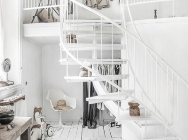 Białe schody w salonie prowadzą na antresolę. Kolorem i subtelną formą wpisują się niemal niezauważalnie w oryginalny...