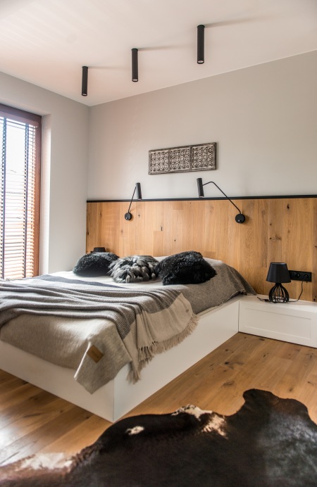 Piękna aranżacja sypialni w szarości z drewnianą ścianą