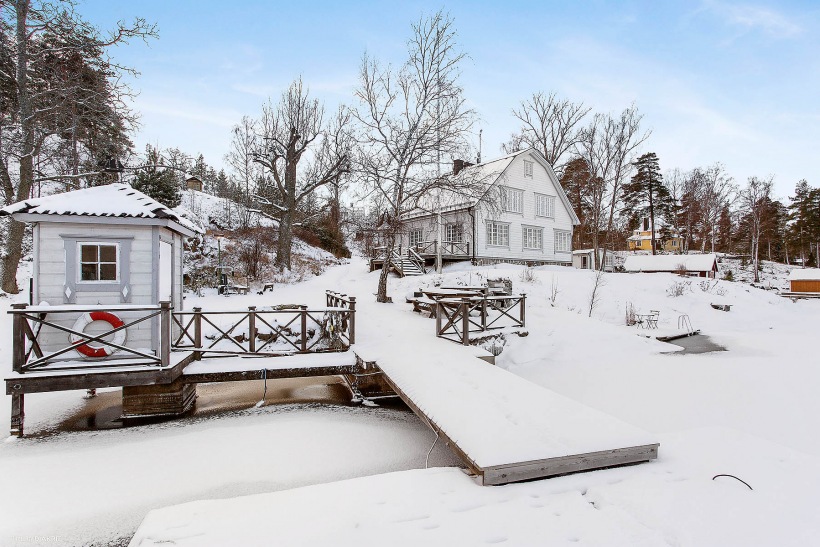 Drewniane tarasy i kładki wokół skandynawskiego domu w zimowej scenerii