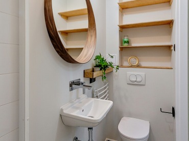 W łazience postawiono na kolory typowe dla stylu skandynawskiego, czyli biel i ciepły odcień drewna. Wzorzysta podłoga...